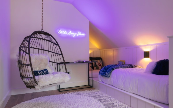 Symmetrical kids bedroom featuring two low platform beds, plush pillows, woven rugs, and soft wall sconces